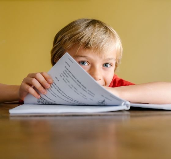 Enfant en IEF ou au CNED travaillant à la maison sous le regard attentif d’un parent